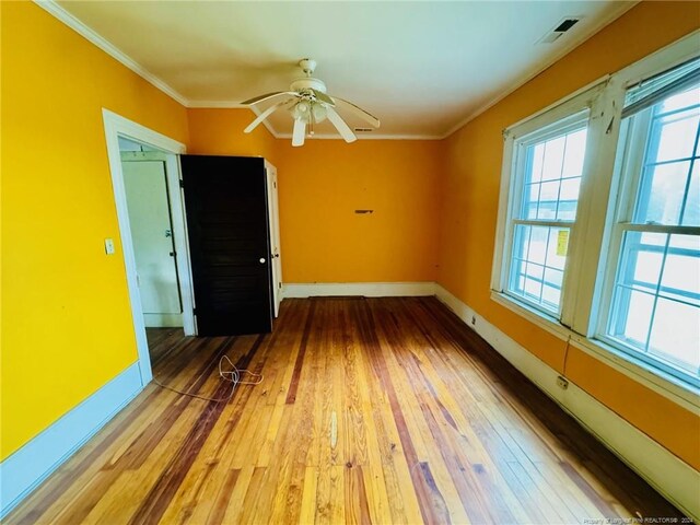 empty room with ceiling fan, hardwood / wood-style flooring, ornamental molding, and a baseboard heating unit