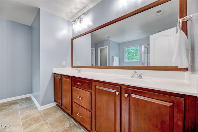 bathroom with vanity, a shower with shower door, and tile patterned floors