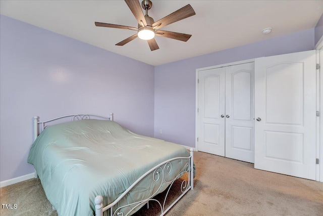 carpeted bedroom with ceiling fan and a closet