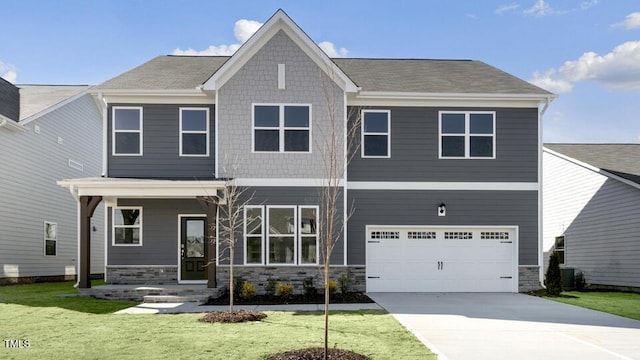 craftsman-style home with a front yard, stone siding, an attached garage, and concrete driveway