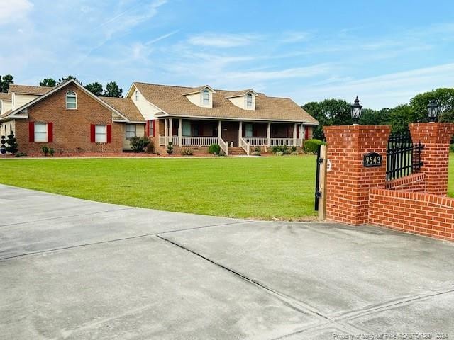 view of front of home with covered porch and a front lawn