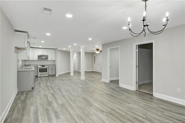 unfurnished living room with sink, ceiling fan, and light hardwood / wood-style flooring