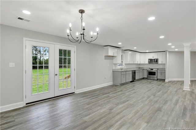 kitchen featuring white cabinetry, light wood-type flooring, french doors, and appliances with stainless steel finishes