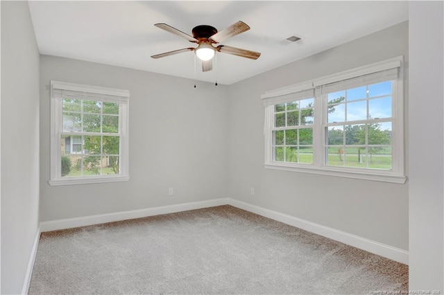 spare room featuring plenty of natural light, carpet flooring, and ceiling fan