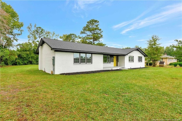 view of front of house with a front yard and brick siding