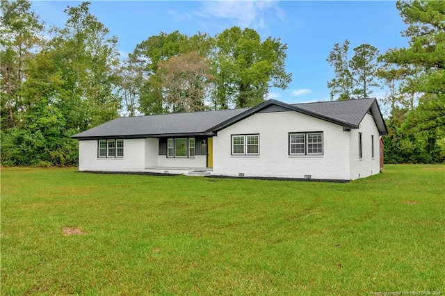 view of front of property featuring brick siding, crawl space, and a front yard