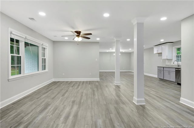 unfurnished living room with recessed lighting, a sink, visible vents, baseboards, and light wood finished floors