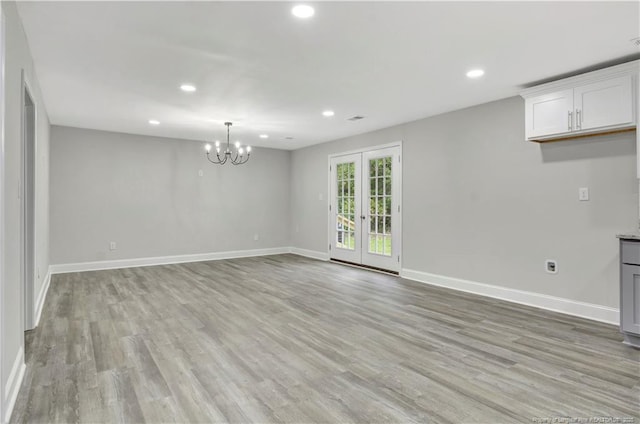 interior space featuring light wood finished floors, baseboards, french doors, a notable chandelier, and recessed lighting