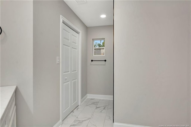 hallway with recessed lighting, marble finish floor, and baseboards