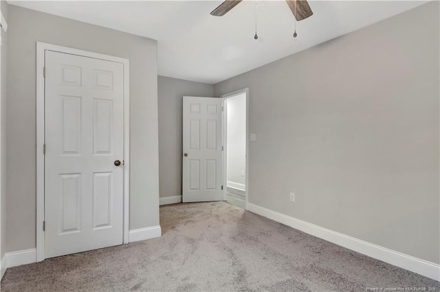 unfurnished bedroom featuring ceiling fan, carpet, and baseboards