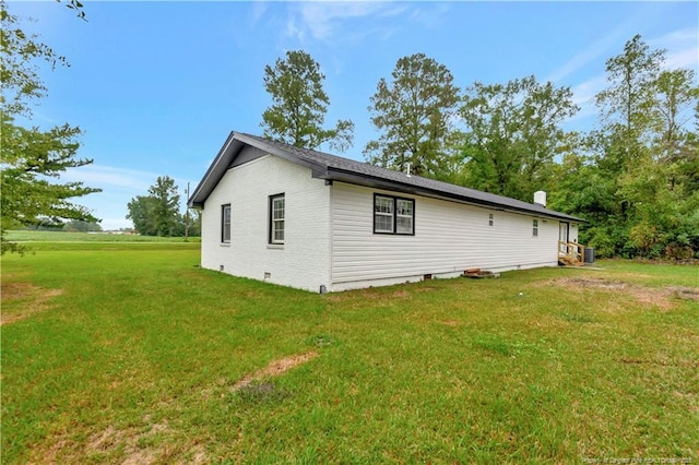 view of home's exterior with crawl space, brick siding, and a yard