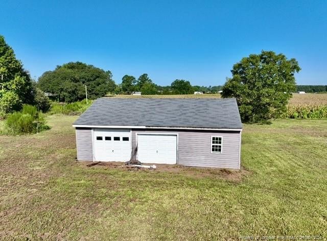 view of outdoor structure with a lawn and a garage