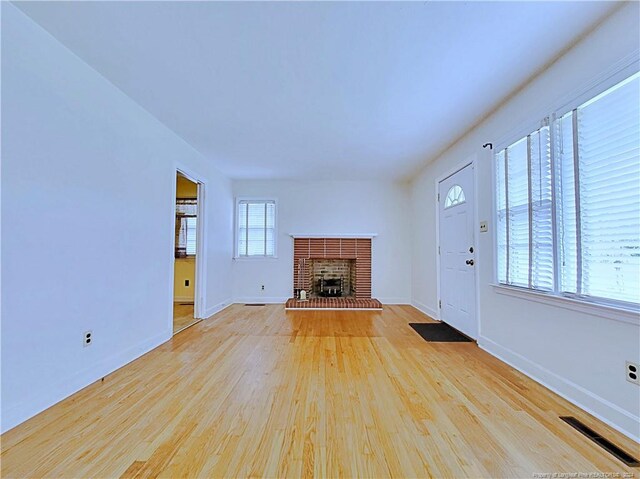 unfurnished living room featuring light wood-type flooring and a fireplace