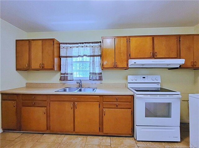 kitchen featuring washer / dryer, electric stove, light tile patterned floors, and sink