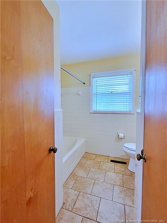 bathroom featuring tile walls, shower / bath combination, tile patterned floors, and toilet