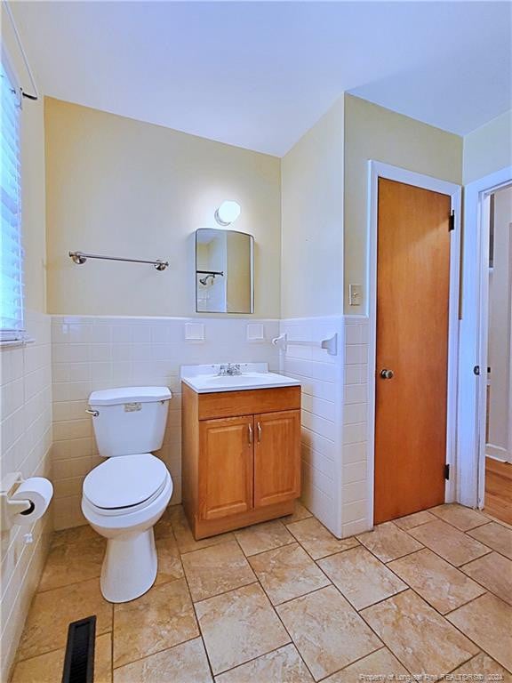 bathroom with tile walls, vanity, and toilet