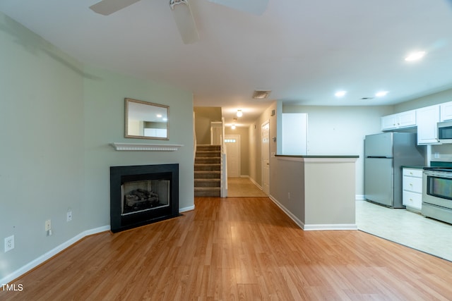 unfurnished living room with ceiling fan and light hardwood / wood-style flooring