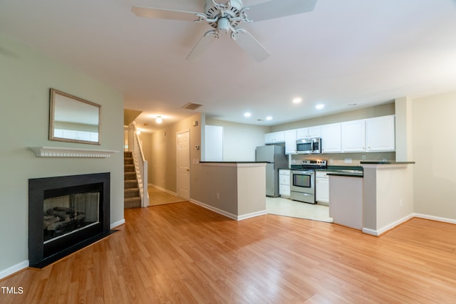 kitchen featuring light hardwood / wood-style floors, ceiling fan, stainless steel appliances, and white cabinets