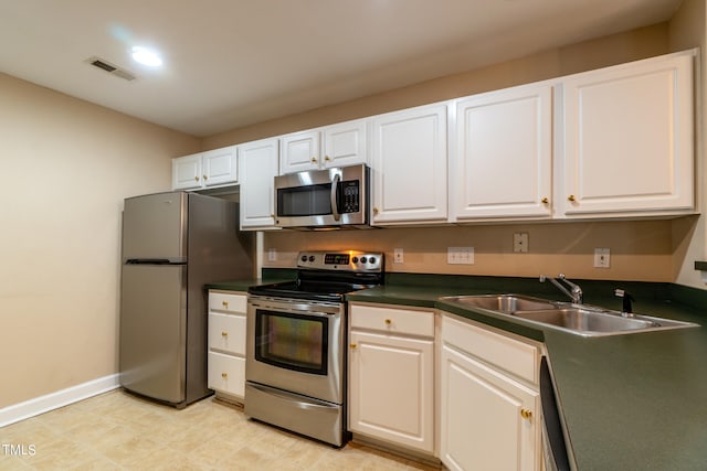 kitchen featuring appliances with stainless steel finishes, sink, and white cabinets