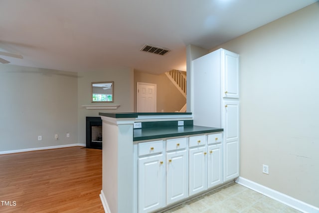 kitchen featuring ceiling fan, white cabinets, light hardwood / wood-style floors, and kitchen peninsula