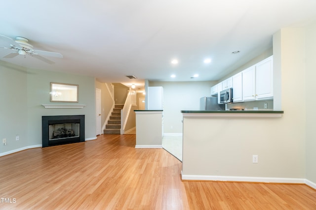 unfurnished living room featuring light hardwood / wood-style flooring and ceiling fan