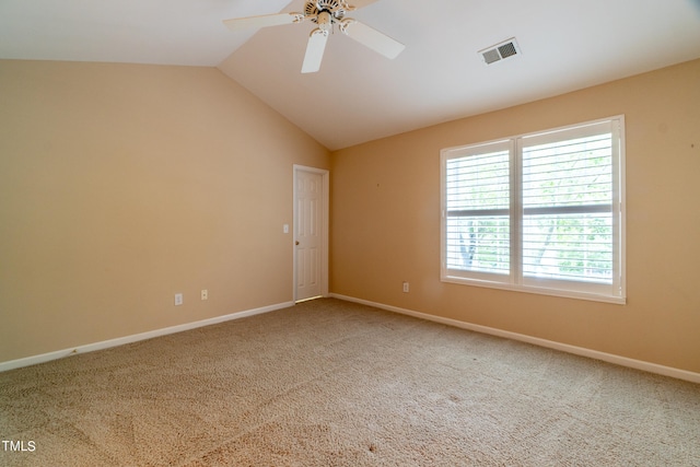 spare room featuring carpet floors, vaulted ceiling, and ceiling fan