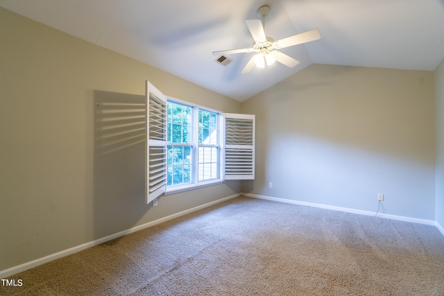 spare room with ceiling fan, lofted ceiling, and carpet flooring