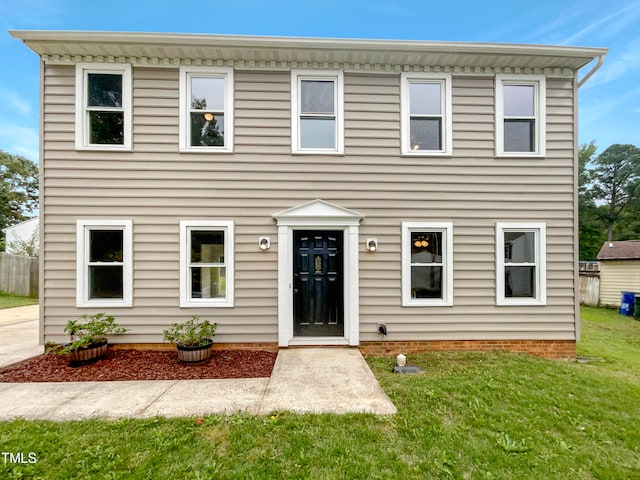 colonial inspired home featuring a front lawn