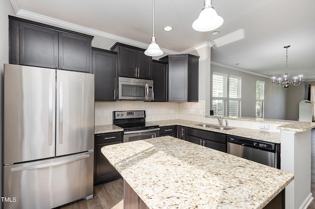 kitchen with decorative light fixtures, appliances with stainless steel finishes, and a center island