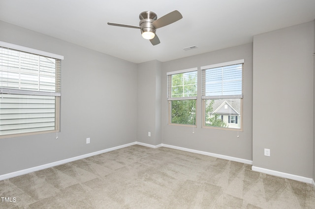 spare room featuring light colored carpet and ceiling fan