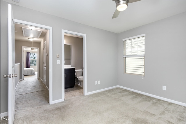 unfurnished bedroom with light carpet, ceiling fan, and connected bathroom