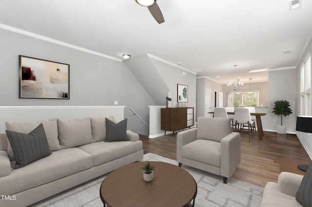 living room featuring ornamental molding, hardwood / wood-style floors, and ceiling fan with notable chandelier