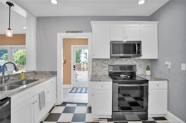 kitchen featuring stainless steel appliances, white cabinetry, and a wealth of natural light