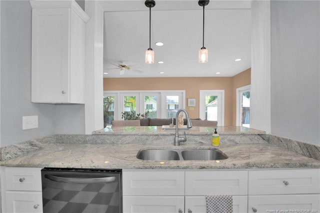 kitchen featuring ceiling fan, white cabinets, sink, dishwasher, and light stone countertops