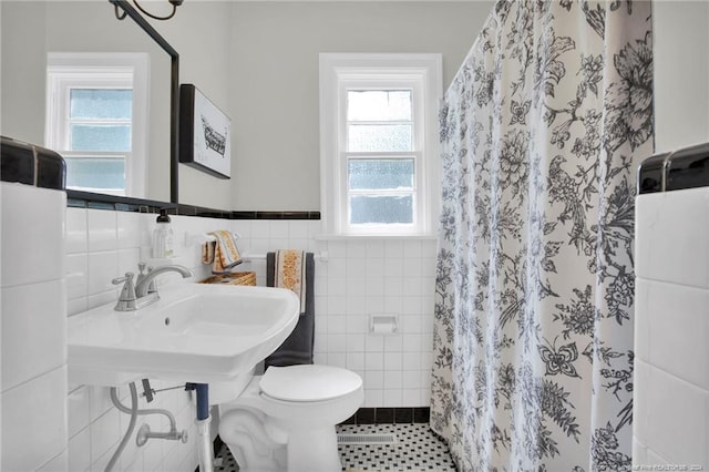 bathroom with tile patterned flooring, tile walls, a shower with curtain, and toilet