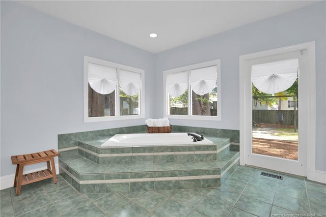 bathroom with tiled bath and tile patterned floors