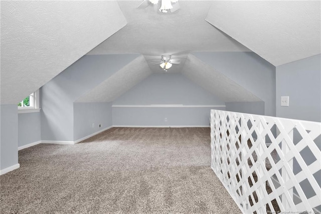 bonus room with ceiling fan, a textured ceiling, lofted ceiling, and carpet