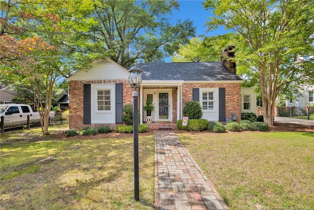 507 Huske St, Fayetteville, NC 28305 - view of front facade featuring a front lawn, fence, brick siding, and a chimney
