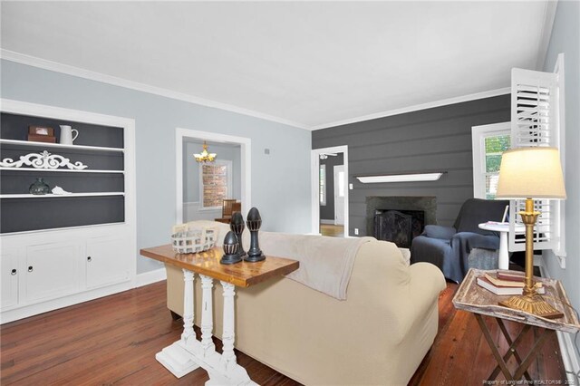 507 Huske St, Fayetteville, NC 28305 - living area featuring built in shelves, ornamental molding, a fireplace, a chandelier, and dark wood-style flooring