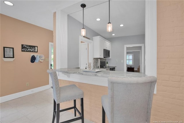 507 Huske St, Fayetteville, NC 28305 - kitchen with electric range, a breakfast bar, white cabinetry, black microwave, and baseboards