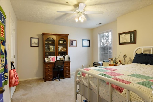 bedroom featuring light carpet, a textured ceiling, and ceiling fan