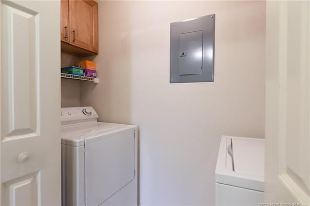 washroom with cabinets, independent washer and dryer, and electric panel