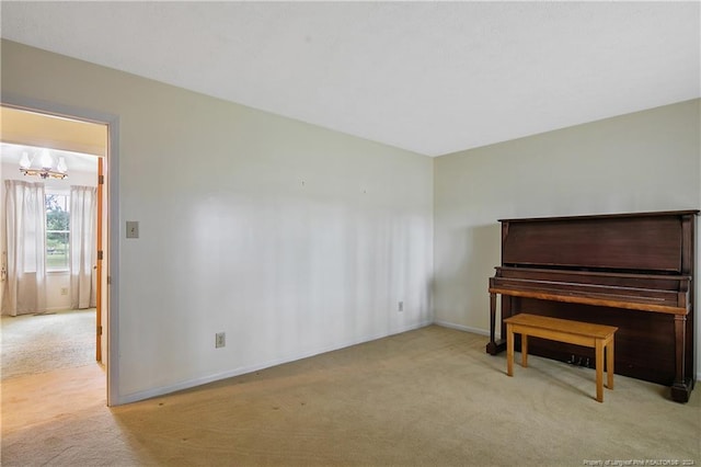 misc room with light colored carpet and a chandelier