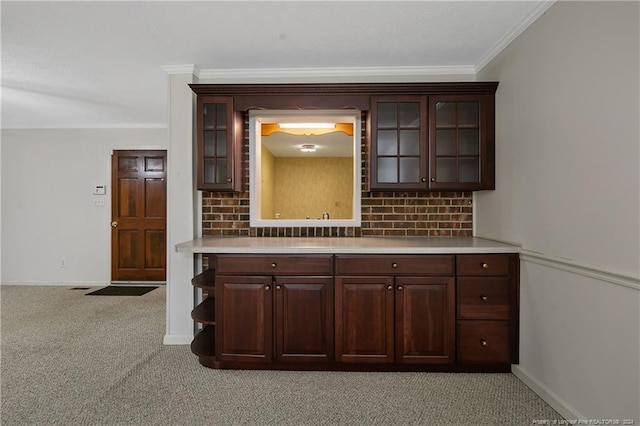 kitchen featuring dark brown cabinetry, light colored carpet, and ornamental molding