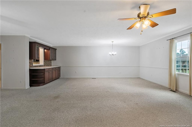 unfurnished living room featuring ceiling fan with notable chandelier and light carpet