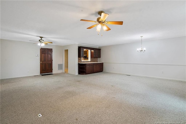 unfurnished living room with ceiling fan with notable chandelier and light colored carpet