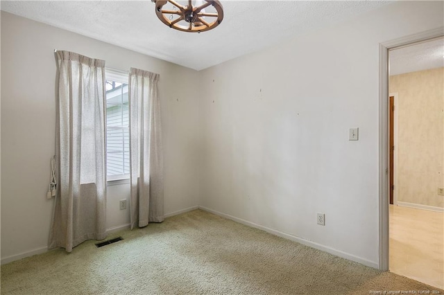 carpeted empty room with a wealth of natural light and a textured ceiling