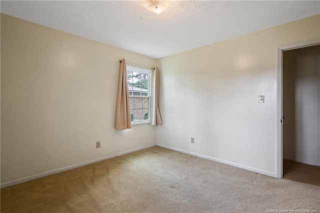 carpeted empty room with a textured ceiling