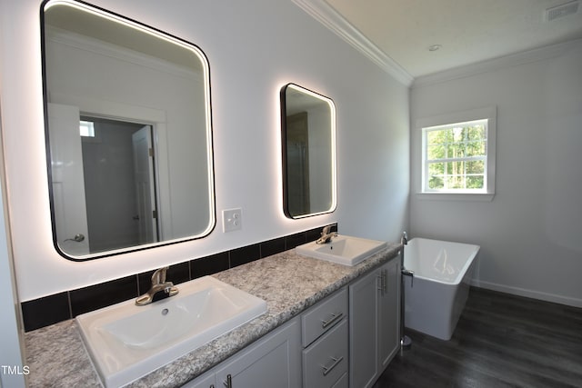 bathroom featuring a bath, vanity, hardwood / wood-style flooring, and crown molding