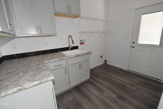 laundry room featuring electric dryer hookup, cabinets, dark wood-type flooring, sink, and washer hookup